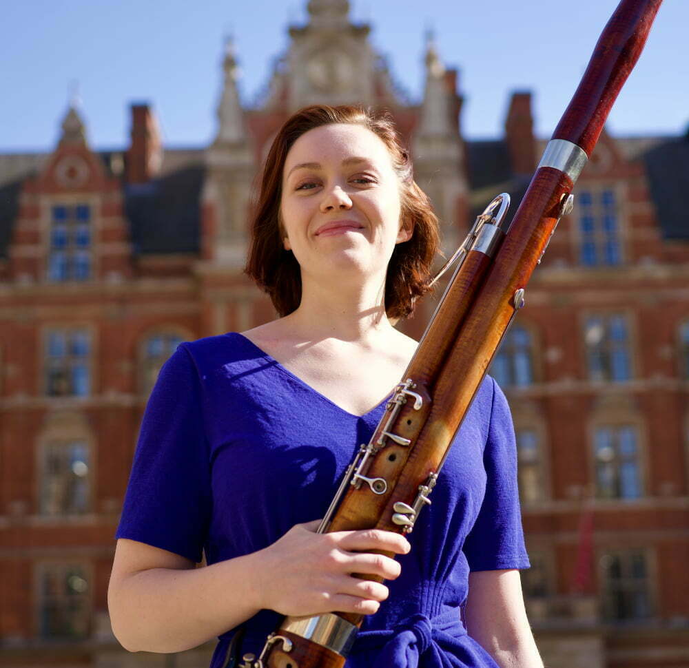 Holly Redshaw with bassoon smiling outside the Royal College of Music